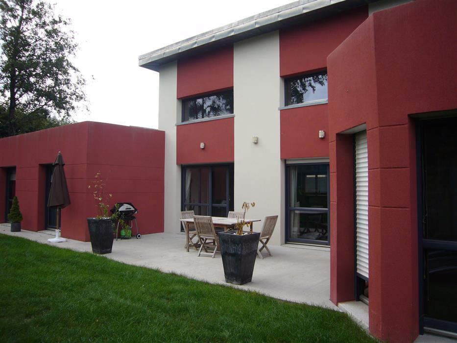 Maison individuelle rénovée avec de la peinture extérieure dans les tons de gris, rouges et tons sombres
