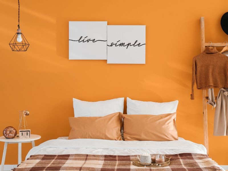 Quarto com parede pintada de laranja e decoração laranja