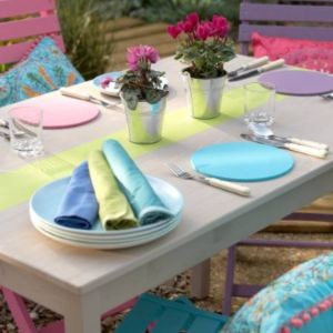 Mesa num jardim com pratos e guardanapos azuis